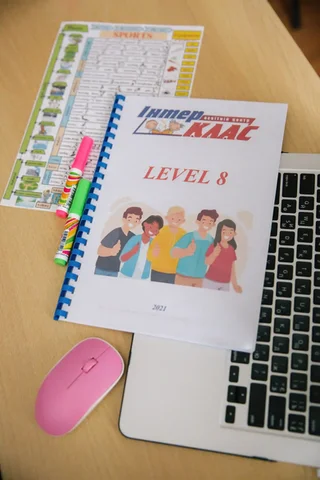 Підручник Interclass Level 8 і навчальні матеріали біля ноутбука